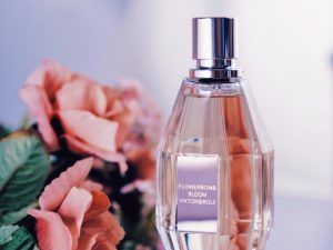 a bottle of perfume next to a bouquet of flowers